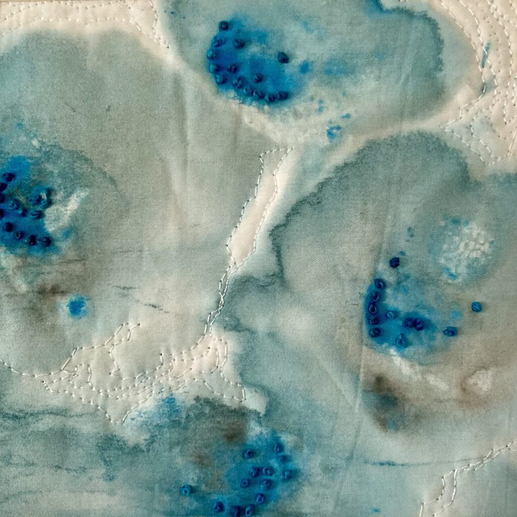 Abstraktes, weiß-blaues Textilwerk mit fließenden Übergängen und punktuellen blauen Farbakzenten.