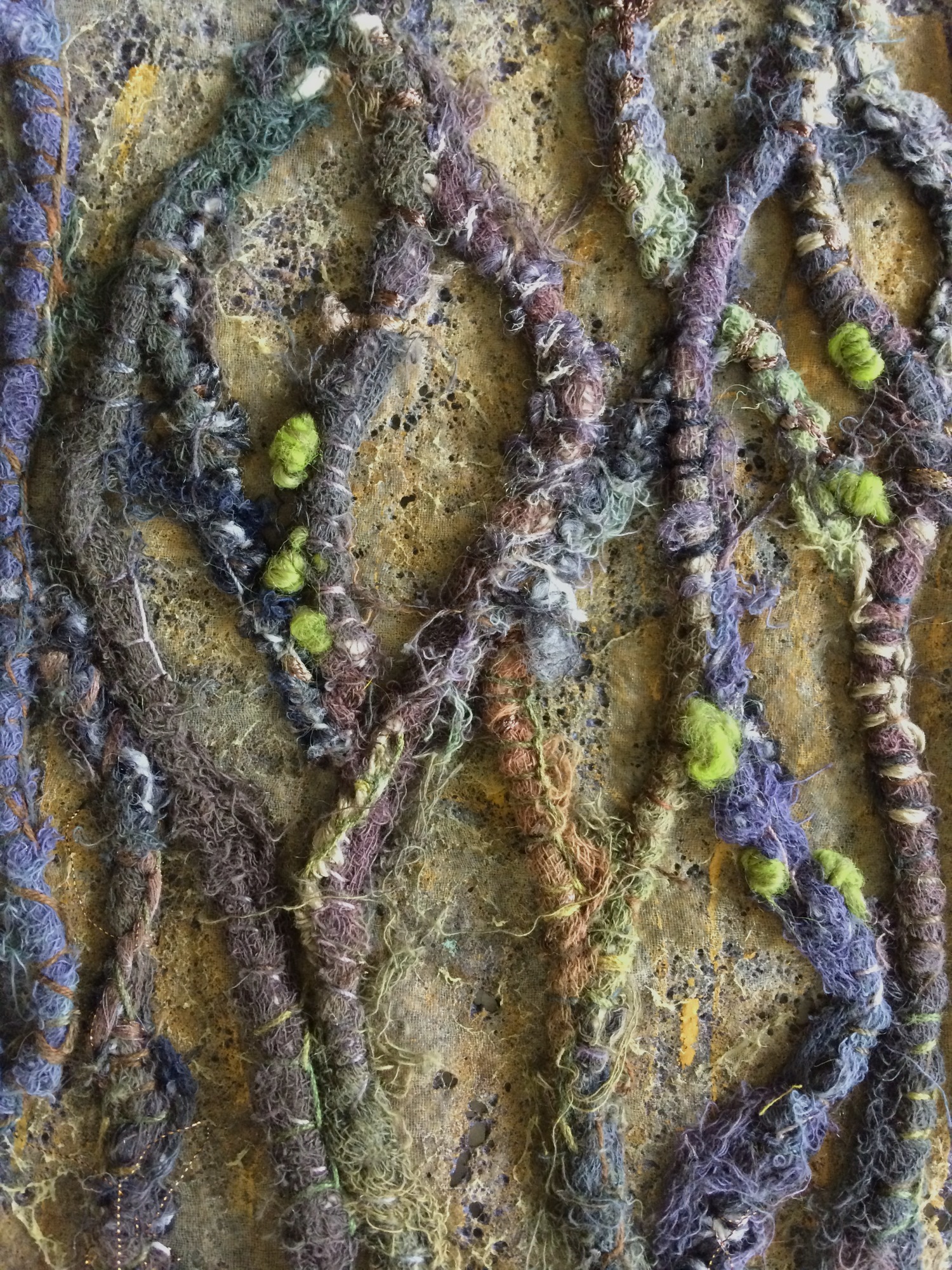 Textile Struktur in Grün- und Brauntönen mit vertikalen Mustern, es sieht aus wie Baumrinde.