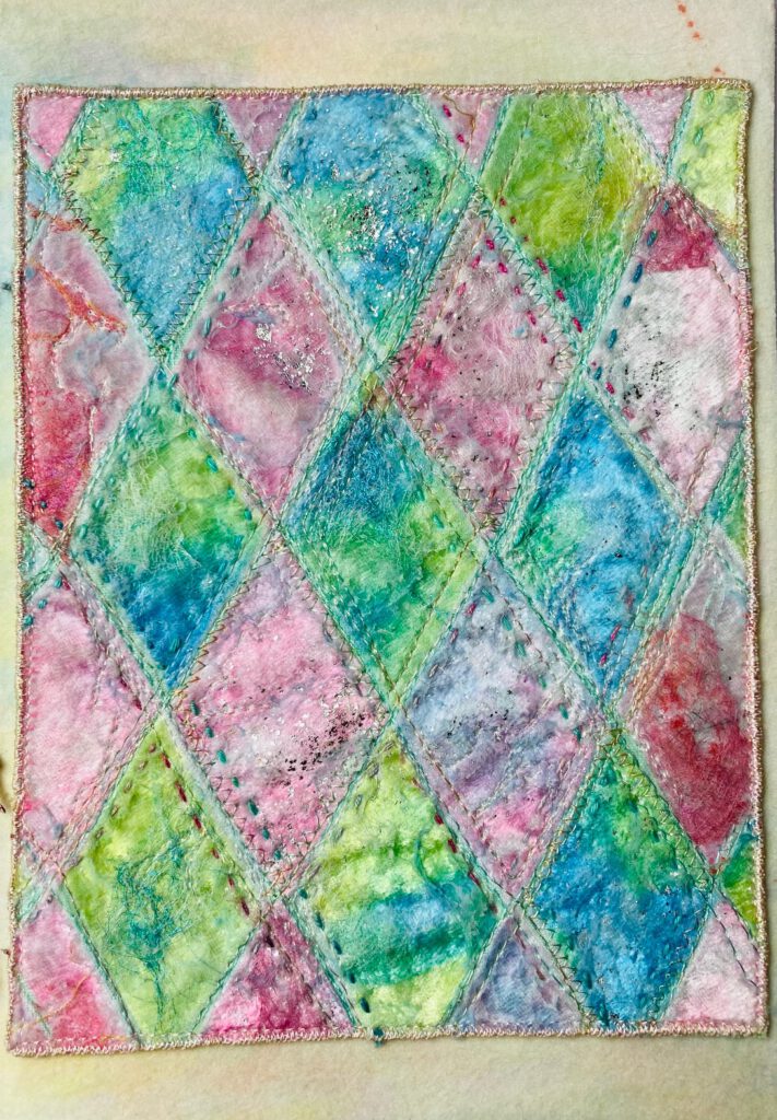 in buntes Rautenmuster in Aquarell-Optik (Blau, Grün, Pink) mit betonten Nähten.