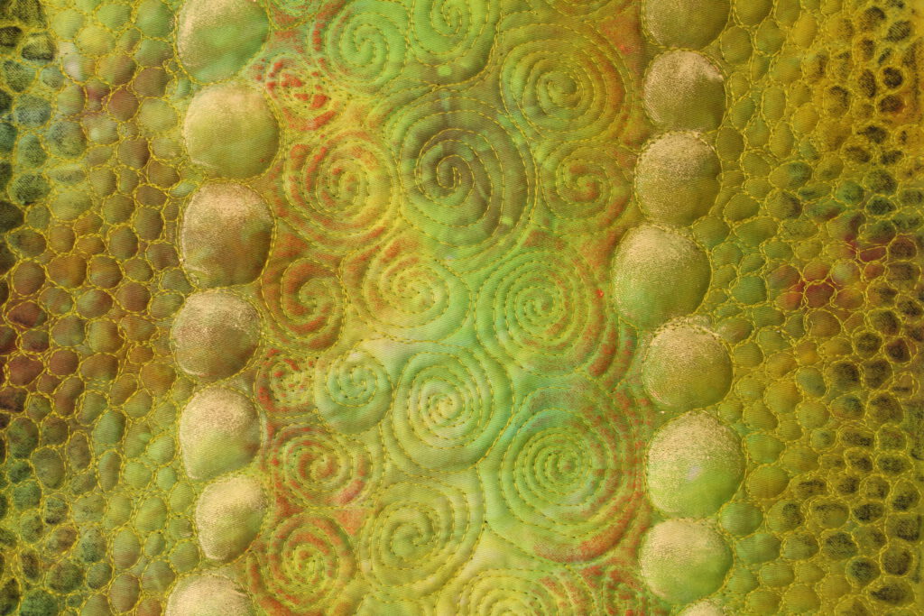Organische, gelb-grüne Textilstruktur mit runden Formen im Quilt.