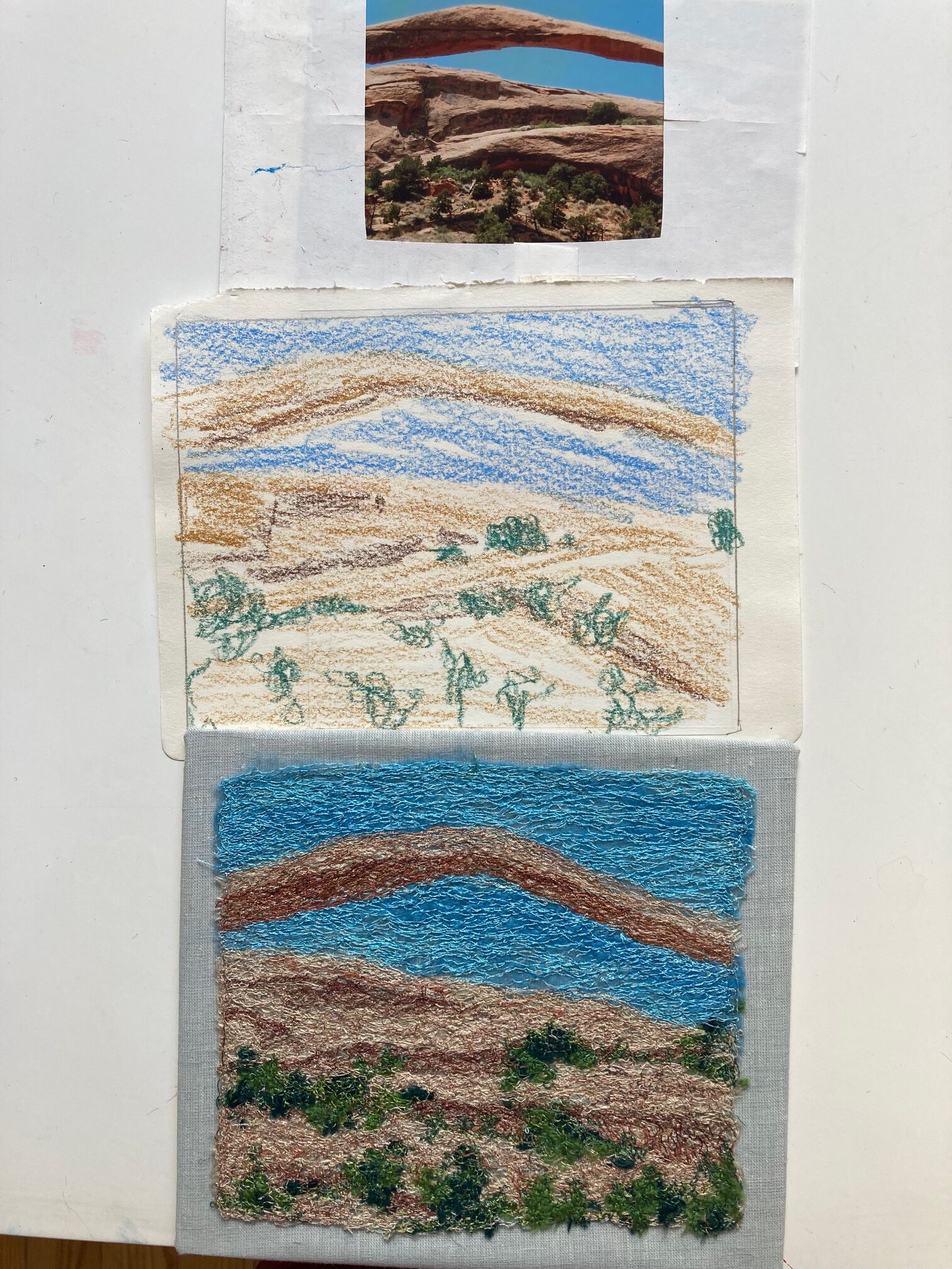 Ein Vergleich zwischen Skizzen und deren textiler Umsetzung: Oben eine strahlende Sonne, unten eine sanfte Hügellandschaft in Blau- und Beigetönen.